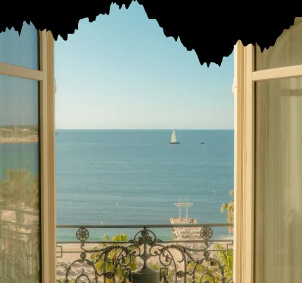 Open window onto the sea with a sailing boat on the horizon